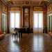 ...arricchito da un pianoforte a coda e una splendida specchiera alta quanto la parete